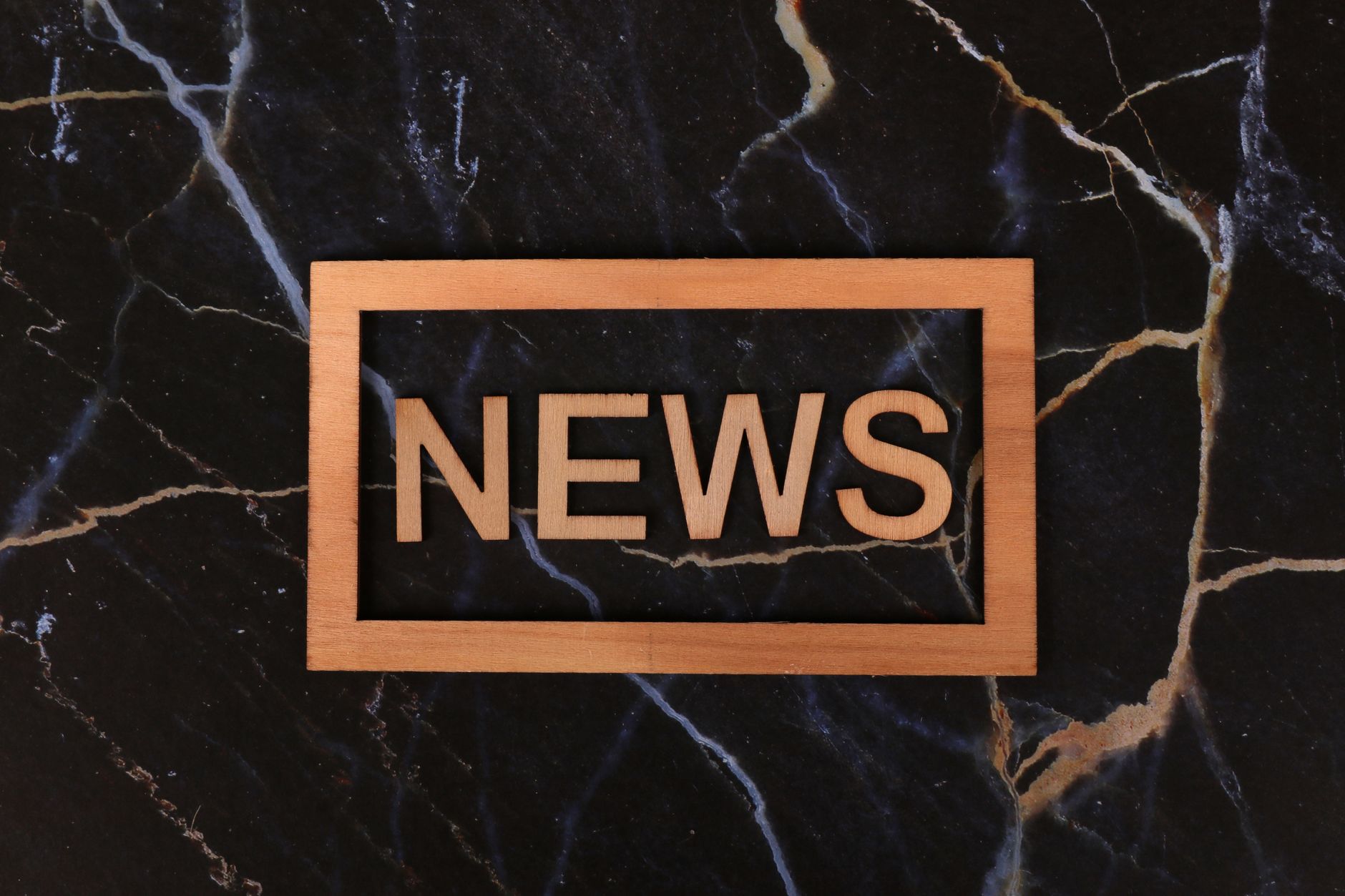 Wooden text of 'news' outlined on a dark, marbled surface, creating a striking contrast. — B7 Casino: Erfahrungen von Stammsp