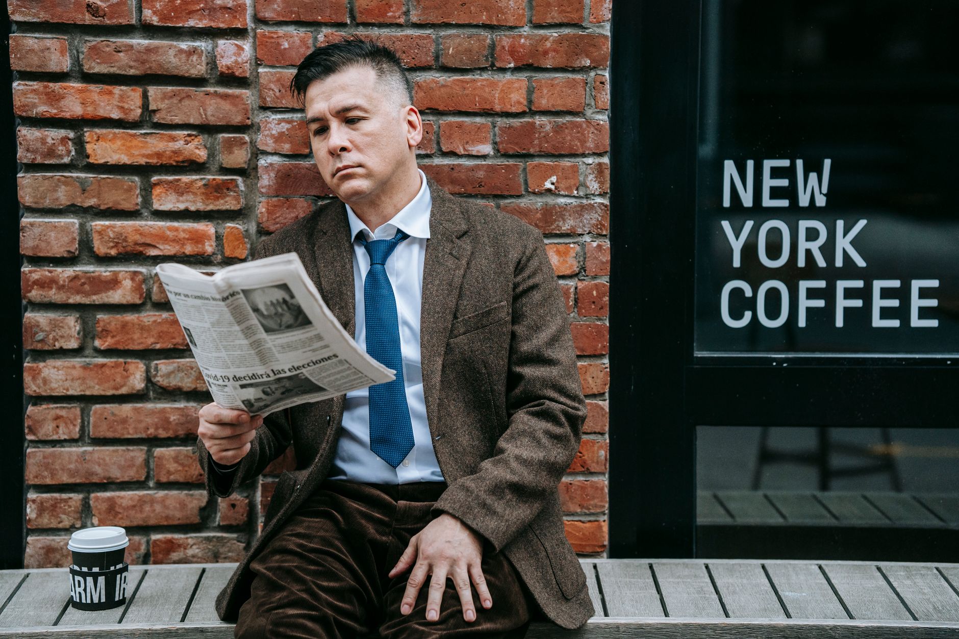 A professional man in formal wear reads a newspaper beside a coffee shop window. — Comment Winnita Casino garantit un fair pl