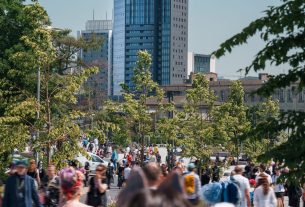 Vibrant crowd enjoying Pyrkon convention in urban Poznań with skyscrapers lining the skyline. — Coronavirus disease 2019