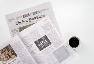 Flat lay of a coffee cup and The New York Times newspaper, ideal for business and lifestyle themes. — Gibt es besondere Promo
