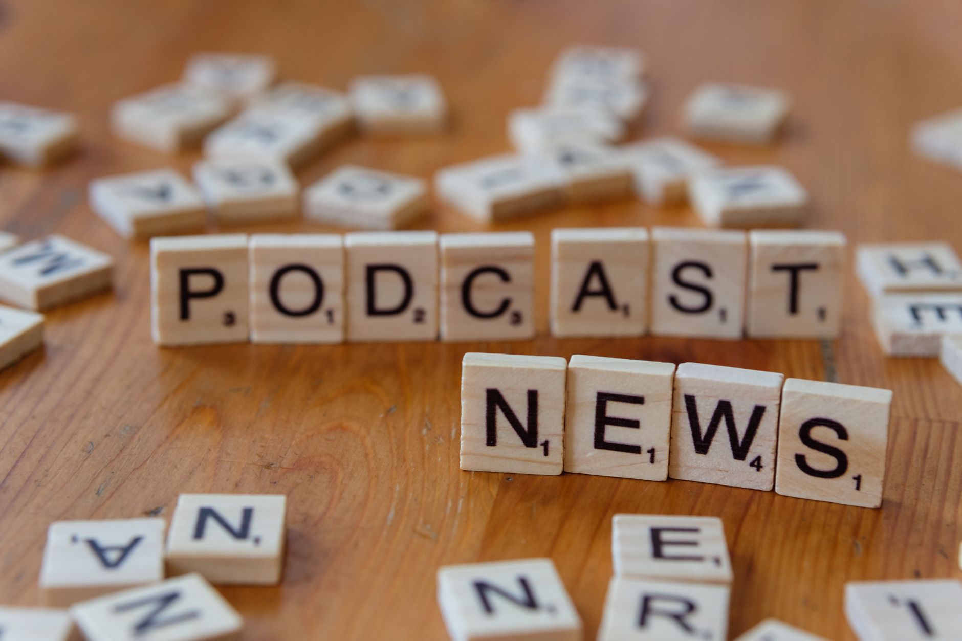 Wooden letter tiles spelling out 'PODCAST NEWS' on a wooden surface. — Lohnt sich B7 Casino? Eine objektive Analyse