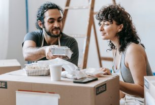 A couple relaxes with takeout food amidst moving boxes in their new home. — Wie oft gibt es neue Aktionen im Glitch Spin Casi