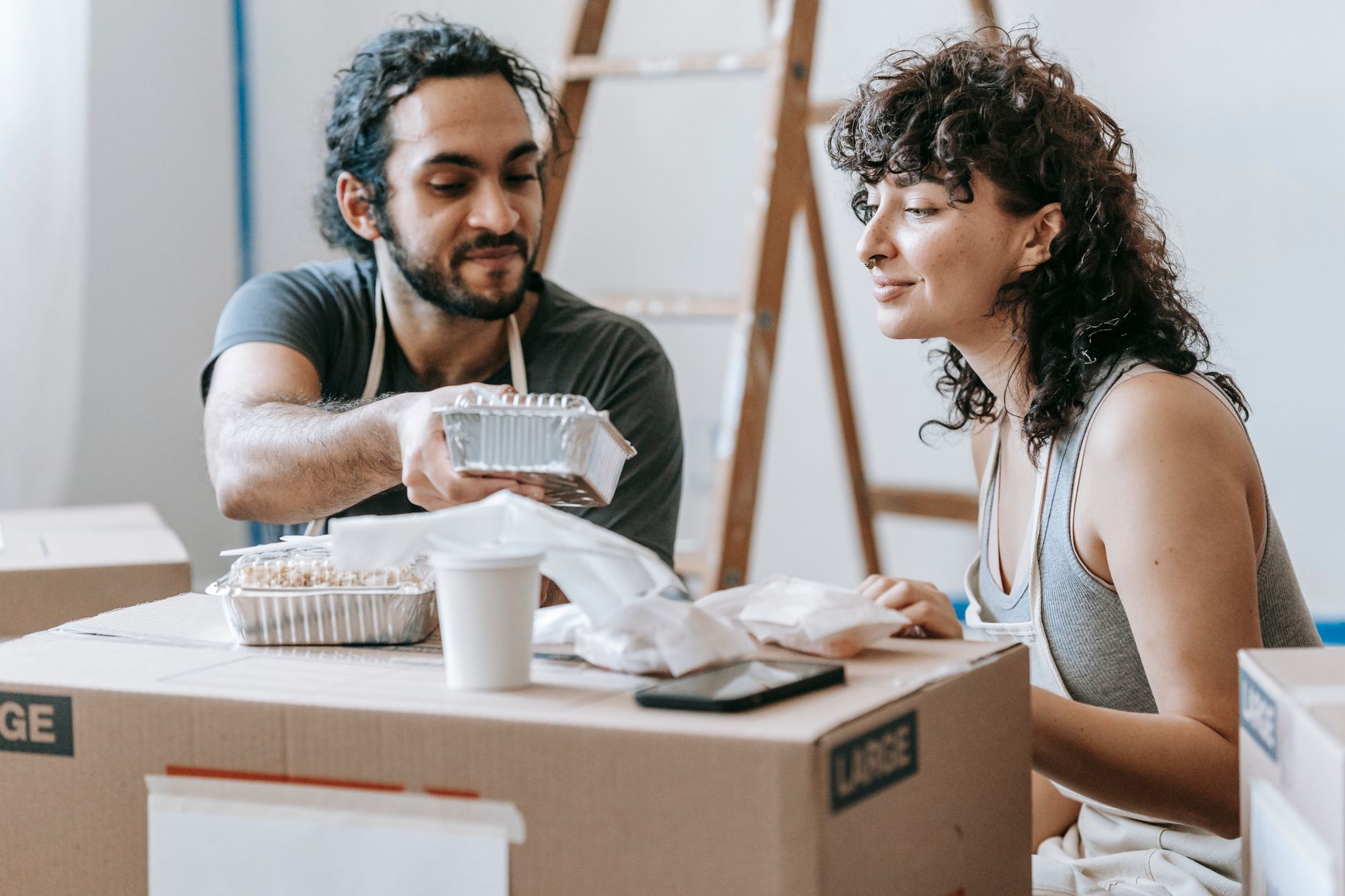 A couple relaxes with takeout food amidst moving boxes in their new home. — Wie oft gibt es neue Aktionen im Glitch Spin Casi